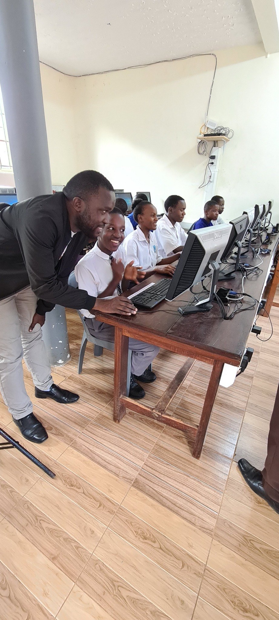 A teacher supporting a student in the computer laboratory